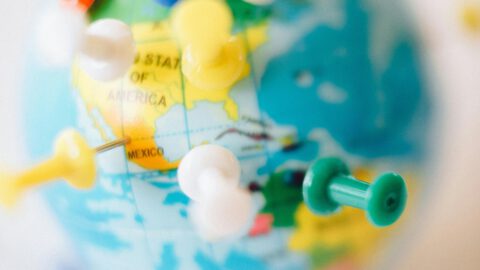 A vibrant globe with colorful pins marking destinations, symbolizing travel plans.