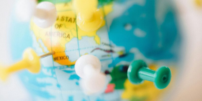 A vibrant globe with colorful pins marking destinations, symbolizing travel plans.